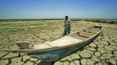 An Iraqi man walks past a canoe siting on dry, cracked earth in the Chibayish marshes near the southern Iraqi city of Nasiriyah on June 25, 2015. Marsh areas in southern Iraq have been affected since the Islamic State group started closing the gates of a dam on the Euphrates River in the central city of Ramadi, which is under the jihadist group's control. AFP PHOTO / HAIDAR HAMDANI        (Photo credit should read HAIDAR HAMDANI/AFP/Getty Images)